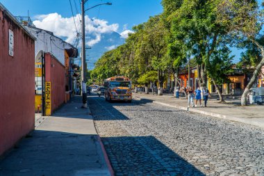 Antigua, Guatemala - 26 Eylül 2021 - kaldırımlı bir caddede turuncu tavuk ve motosiklet