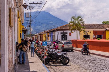Antigua, Guatemala - 26 Eylül 2021 - İnsanların, sömürge evlerinin ve motosikletlerin sokak fotoğrafları