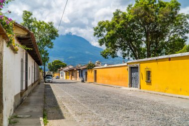 Antigua, Guatemala - 27 Eylül 2021 - arka planda koloni evleri ve Agua Volkanı olan bir cadde