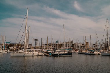 Barcelona, İspanya - 15 Nisan 2021 - Barcelona limanında yelkenli tekne ve motorlu tekne panoramik günbatımı manzarası