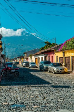 Antigua, Guatemala - 27 Eylül 2021 - arka planda Agua Volkanı olan koloni renkli evlerin dikey sokak çekimi