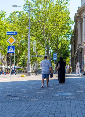 Odessa, Ukrayna - 21 Haziran 2021 - Odessa 'nın merkezinde yürüyen Müslüman bir çiftin dikey sokak fotoğrafı