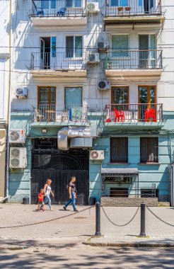 Odessa, Ukrayna - 21 Haziran 2021 - Odessa şehir merkezindeki apartmanların önünde yürüyen bir ailenin dikey görüntüsü