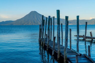 Panajachel, Guatemala 'daki Atitlan Gölü' ndeki ahşap rıhtım ve volkanların panoramik görüntüsü
