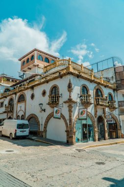 Puerto Vallarta, Meksika - 12 Eylül 2021 - Calle Juarez 'deki geleneksel mimari, araba ve binaların dikey sokak çekimi