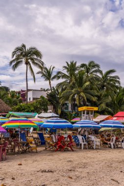 Sayulita, Meksika - 16 Eylül 2021 - Sayulita sahilinde sandalyeler, şemsiyeler ve palmiye ağaçları