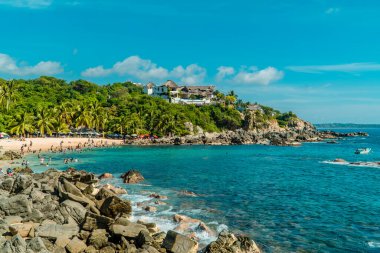 Puerto Escondido, Meksika - 14 Kasım 2021 - Playa Manzanillo 'da yüzen ve güneşlenen insanların panoramik görüntüsü