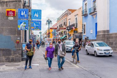 Puebla, Meksika - 28 Ağustos 2021 - Puebla 'nın merkezinde geleneksel binalarla yürüyen bir kalabalığın sokak fotoğrafçılığı