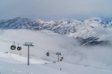 Livigno, Italy - December 28, 2021 - panoramic view of skiers and gondolas on a cloudy day