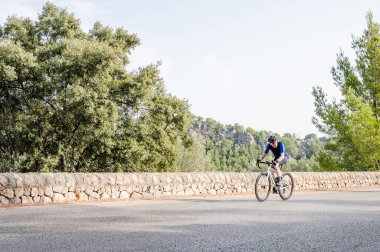 Dağlarda bisiklet süren yaşlı bir sporcu. Kopyalama alanı olan resim