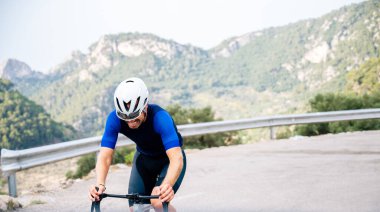 Yol bisikletiyle dağ geçidine tırmanan tanınmamış bir bisikletçi. Kendini aşan bir sporcu