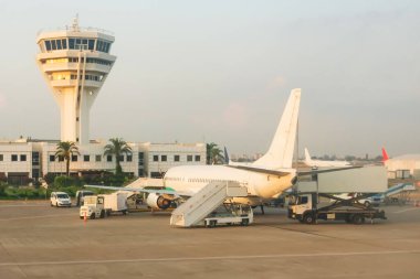 Kontrol kulesinin görüntüsü, etrafındaki hava araçları ve servis araçları, havaalanının hafta içi sabahları