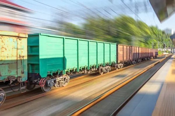 Yük treni son sürat yolcu istasyonunu geçer.