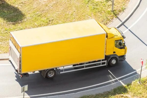 Żółty Samochód Ciężarowy Izolowaną Skrzynką Kontenerową Skręca Autostradzie Widok Lotu — Zdjęcie stockowe