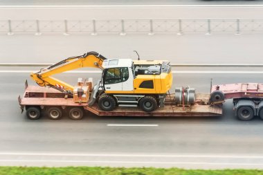Uzun platformlu bir karavan. Kazıcı 'yı otobanda taşıyor. Ağır ve büyük kargoların karayoluyla taşınması..