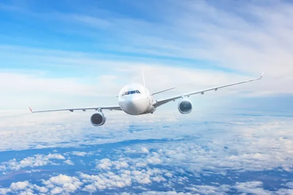 雲の間の青い空の旅客航空会社のフライト — ストック写真