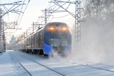 Express train rushes lifting snow into the air winter landscape