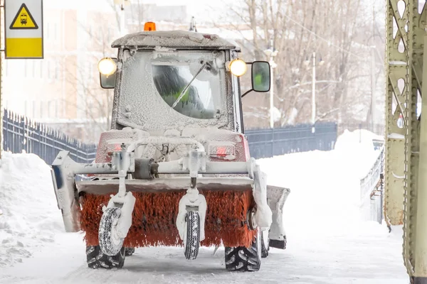 スノープローと回転ブラシで雪からトラクターの清掃歩道 ブラシとスクープ付きの車両は雪を削除 — ストック写真