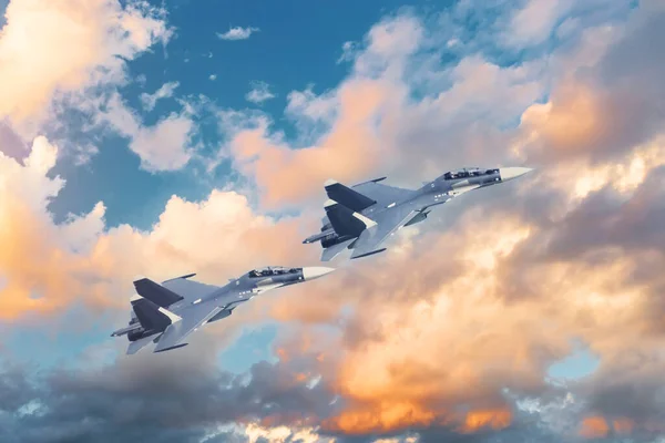 夕日の美しい雲を背景に空を飛ぶタンデム軍用ジェット戦闘機のペア — ストック写真