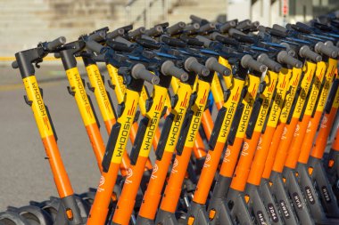 Elektrikli scooterlar kirada kürek çekmek için park edilmiş. Rusya, Soçi, 04 Aralık 2021