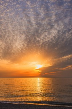Muhteşem bulanık sirrus bulutlarının muhteşem görüntüsü muhteşem bir ışık ve ufuktaki deniz yüzeyinde bir güneş diski.