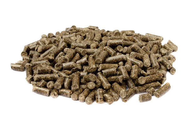 Sunflower granulated feed isolated on white background, close-up. Pile of sunflower meal pellets isolated on white background. Heap of animal feed pellets isolated on white background. — Stock Photo, Image