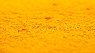 Bir yığın zerdeçal tozu, arka plan, yakın plan. Sarı zerdeçal tozu, doku, arka plan. Hint baharatı, zerdeçal tozu, arka plan. Zerdeçal tozu, doku.