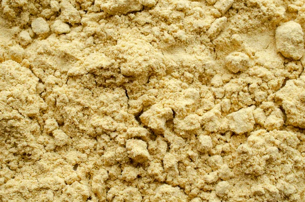 Gul senap pulver bakgrund, ovanifrån. Textur av gult senapspulver, ovanifrån. Heap av senapspulver, krydda, bakgrund, textur. — Stockfoto