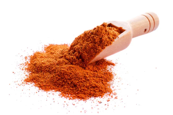 Röd paprika pulver och trä sked isolerad på vit bakgrund. Röd paprika smaksättning med träsked, komposition isolerad på vit bakgrund. Torkat rött pepparpulver i en träsked. Stockfoto