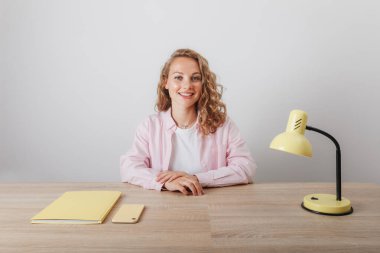 Genç bir kız evde çalışıyor ve okuyor.