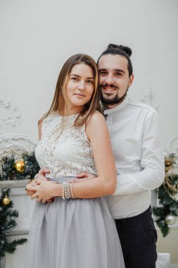 Bir adam yeni yıl tatilinde zarif giyimli kızına sarılır.