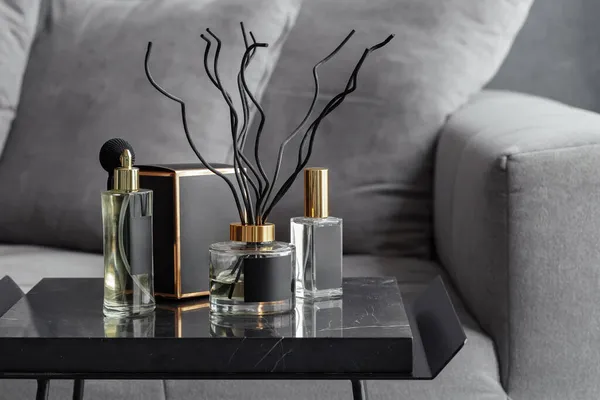 a set of air fresheners and black-packaged diffusers on the black marble table