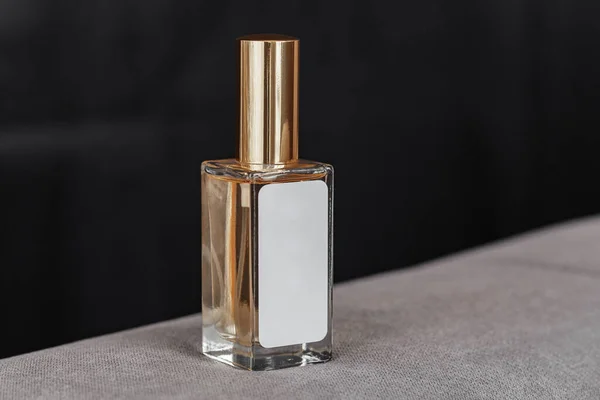 Eine Flasche Parfümspray mit einem Etikett für Text auf dunklem Hintergrund — Stockfoto