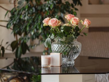 Cam masanın üzerindeki mum ve buket çubuğu eski duvar ve yeşilliklere karşı.