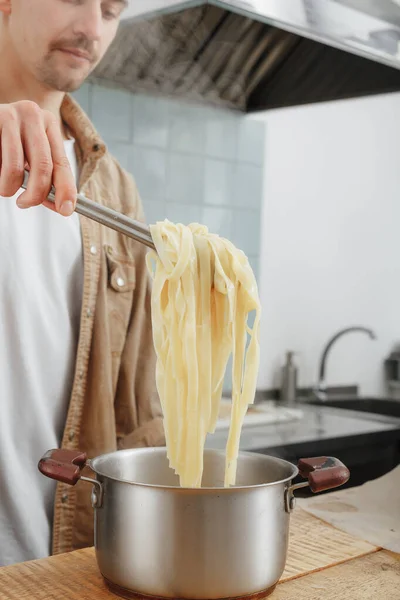 Hombre hace pasta de queso hecha a mano para el almuerzo — Foto de Stock