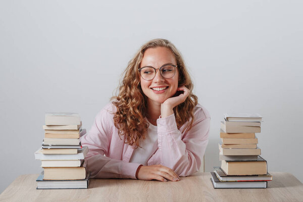 young girl student in glasses and many books