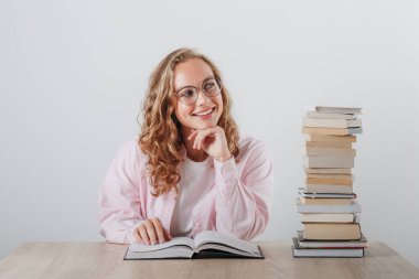 Gözlüklü kız ve bir yığın kitap.