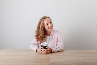 Genç güzel kız öğrenci sabah kahvesini içiyor.