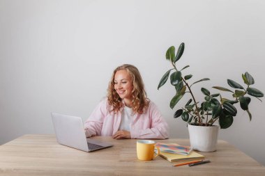 Genç bir kız evde çalışıyor ve okuyor.