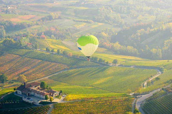 stock image Aerostatic balloons are flying over the hills of Langhe (Piedmont, Northern Italy), covered by vineyards during fall season; UNESCO Site since 2014.