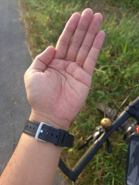 Yolda bir bisikleti tutan el.