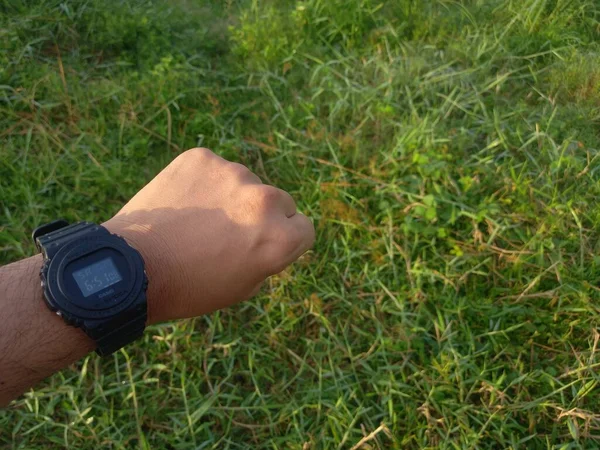 Mężczyzna Pokazujący Zegarek Zaciśniętymi Pięściami Trawiastym Tle Ogrodu — Zdjęcie stockowe