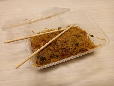 Vermicelli fried or called bihun goreng served in a plastic box with top view photo