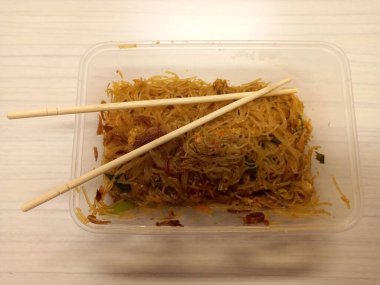 Vermicelli fried or called bihun goreng served in a plastic box with top view photo