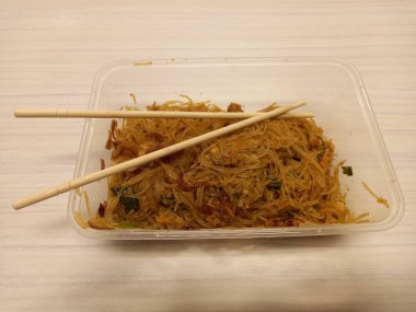 Vermicelli fried or called bihun goreng served in a plastic box with top view photo