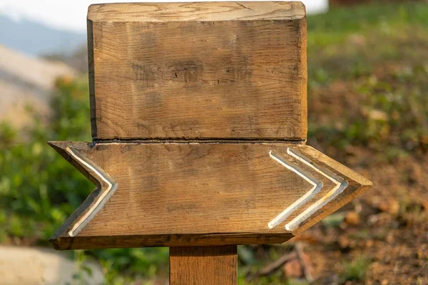 Wooden blank sign in forest with a direction sign.