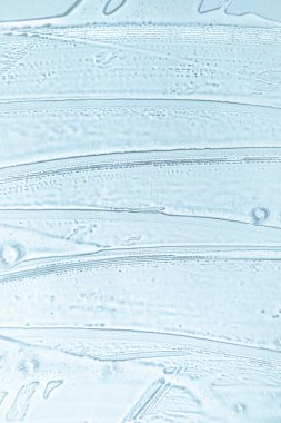 Gel texture background in cold blue colors. Banner for moisturizing cosmetic presentation. Antiseptic wallpaper. Hydration medical. Liquid gel cosmetic smudge. Transparent cosmetic sample