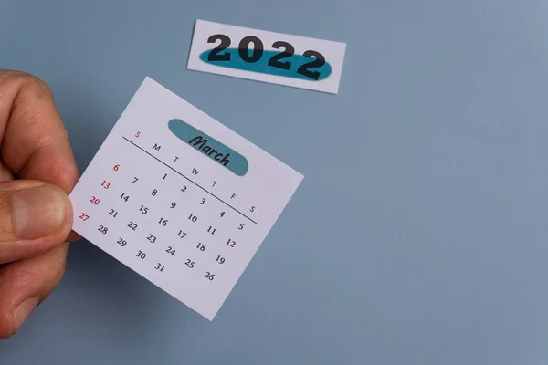 Hand hält einen weißen Märzkalender des Jahres 2022. Neujahrskonzept — Stockfoto