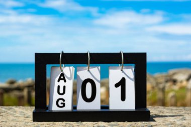 Aug 01 calendar date text on wooden frame with blurred background of ocean. Calendar concept