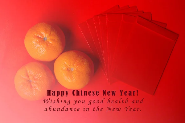 中国の旧正月のコンセプトイメージ テキストと赤の背景にマンダリンオレンジと赤のパケット — ストック写真